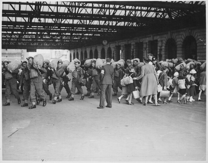 Una escena en una estación de tren de Londres que muestra la llegada de las tropas mientras los niños que están siendo evacuados de Londres se van