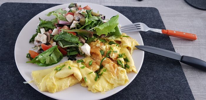 An Omelet. Side Dishes Are Salad, Mushroom, Tomato And Mozzarella