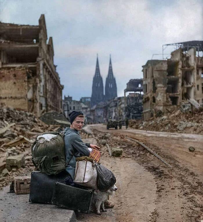 Una mujer alemana con sus pertenencias sentada sola en Colonia arruinada por la guerra. 1945