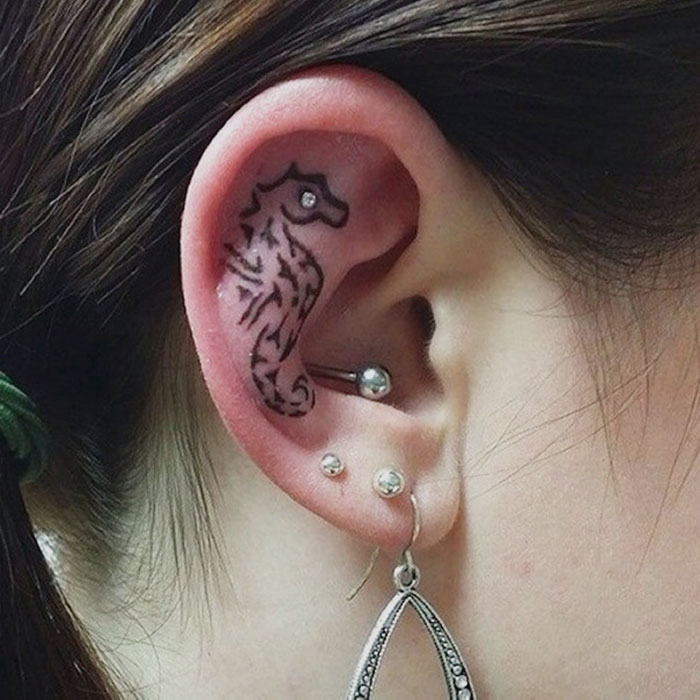 Behind the ear tattoo of a seahorse on Irene