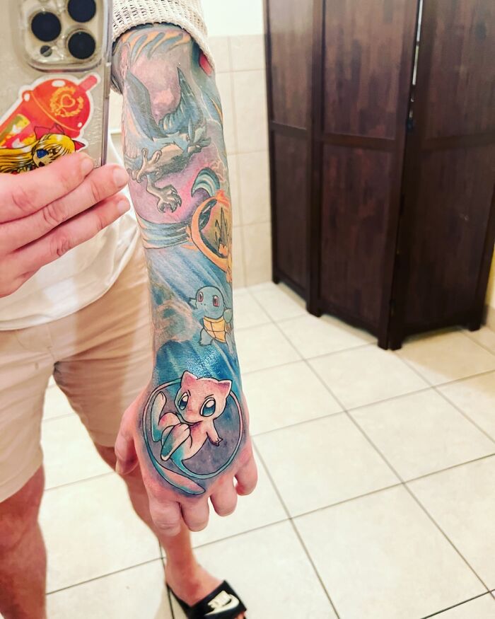 Colorful tattoo sleeve featuring various Pokémon characters on a person's forearm.