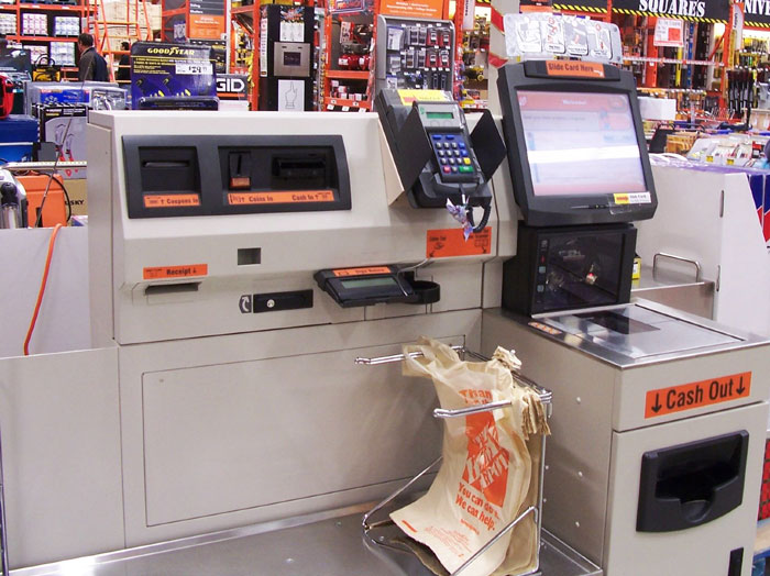 Self-checkout machine in a supermarket aisle. Self-checkout machine in a supermarket aisle.