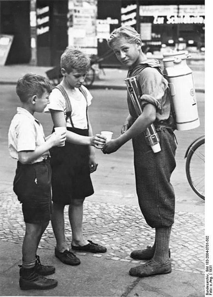 Un niño berlinés vende limonada con un dispensador de limonada portátil, 1931.