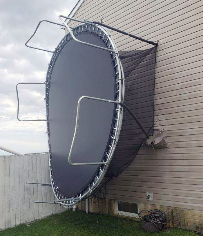 Side Of House Impaled By Trampoline After Severe Weather