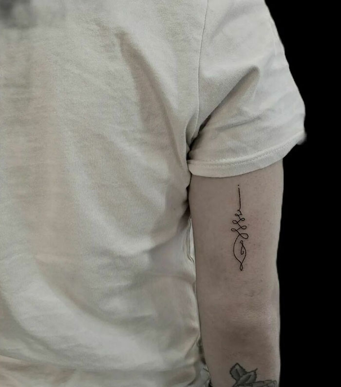 Single line symbol back arm tattoo