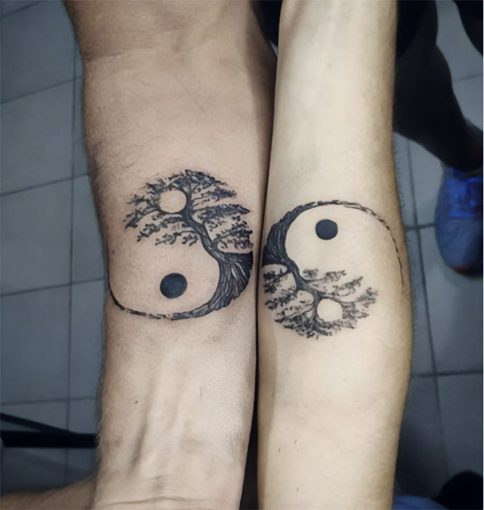 Ying and yang signs with a tree forearm tattoos