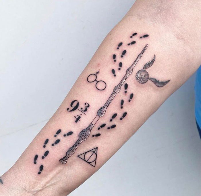 Harry Potter tattoo featuring a wand, glasses, Golden Snitch, 9¾, footprints, and Deathly Hallows symbol on an arm.
