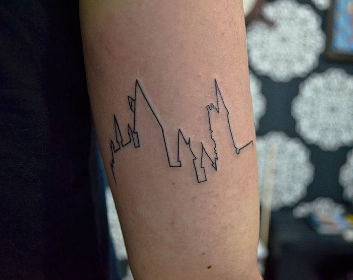 Minimalist Hogwarts tattoo design on forearm, perfect for Harry Potter fans.