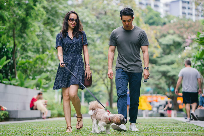 Woman and man walking a dog