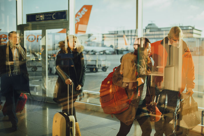 People in the airport going with luggages