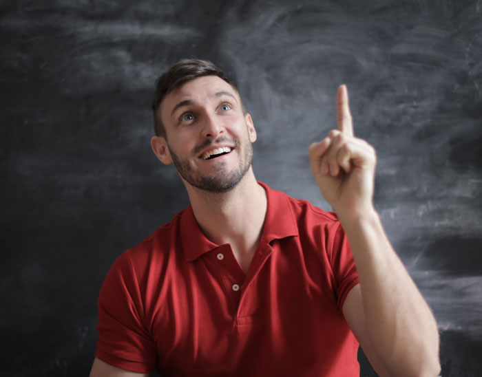 Man wearing red shirt pointing finger up