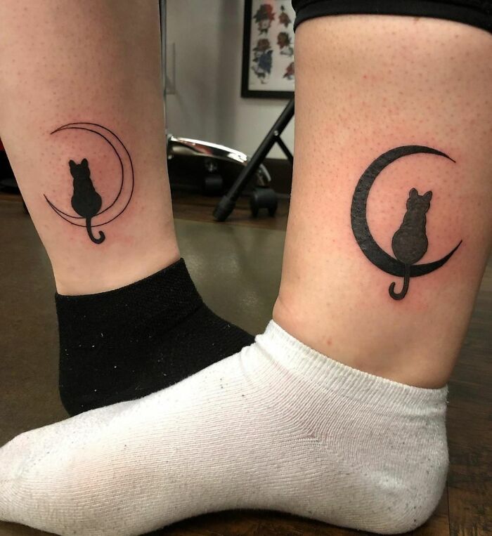 Matching best friend tattoos of silhouetted cats on crescent moons on ankles with mismatched socks.