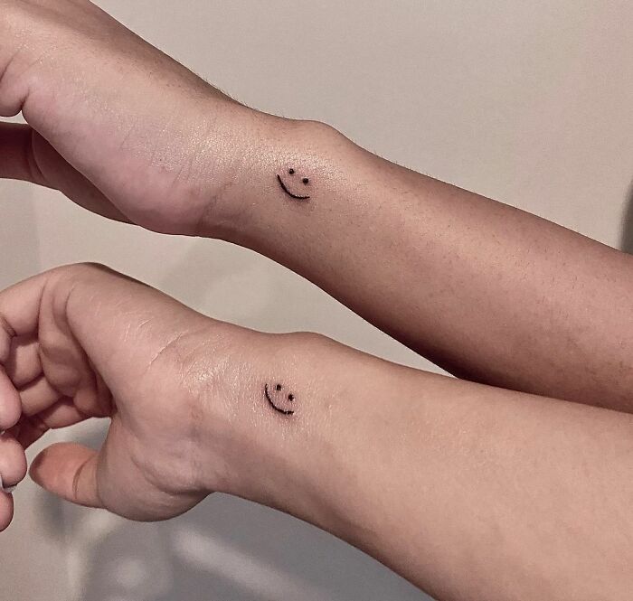 Matching little smiley wrist tattoos