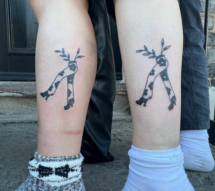Matching floral leg tattoos on two friends' legs symbolizing friendship.