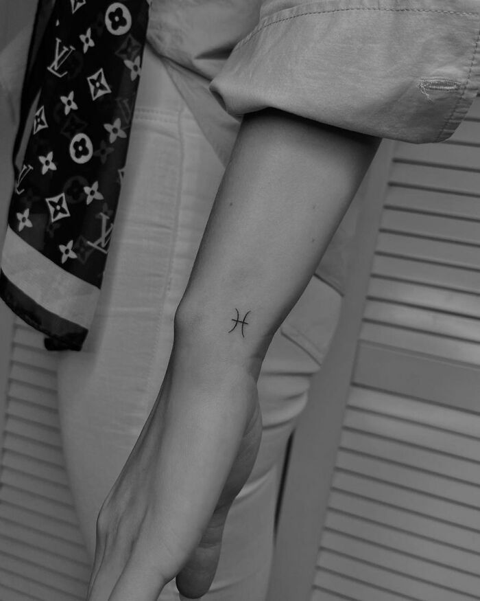 minimalistic tattoo of the pisces sign
