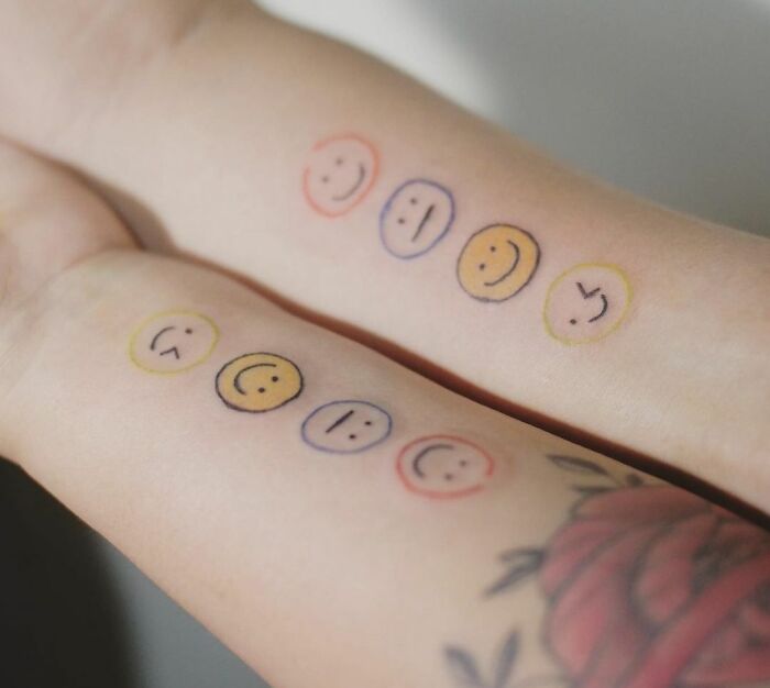 Matching emoji smileys arm tattoos