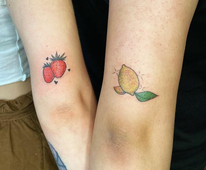 Matching strawberry and lemon arm tattoos