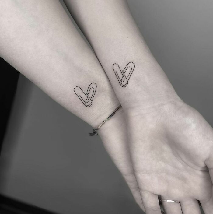 Matching heart-shaped paperclip wrist tattoos