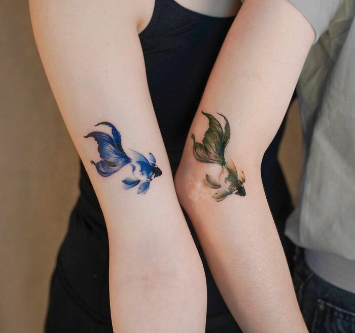Two forearms with best friend tattoos featuring colorful koi fish, symbolizing friendship.