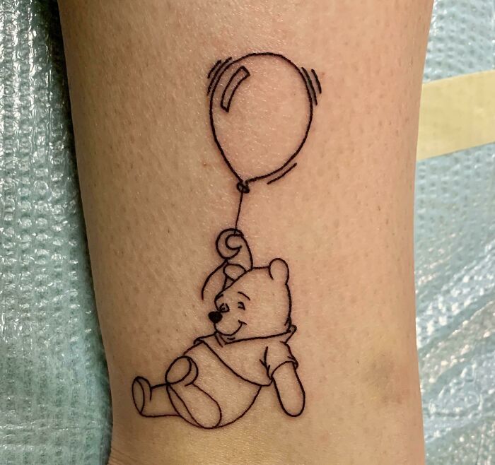 Winnie-the-Pooh holding a balloon tattoo