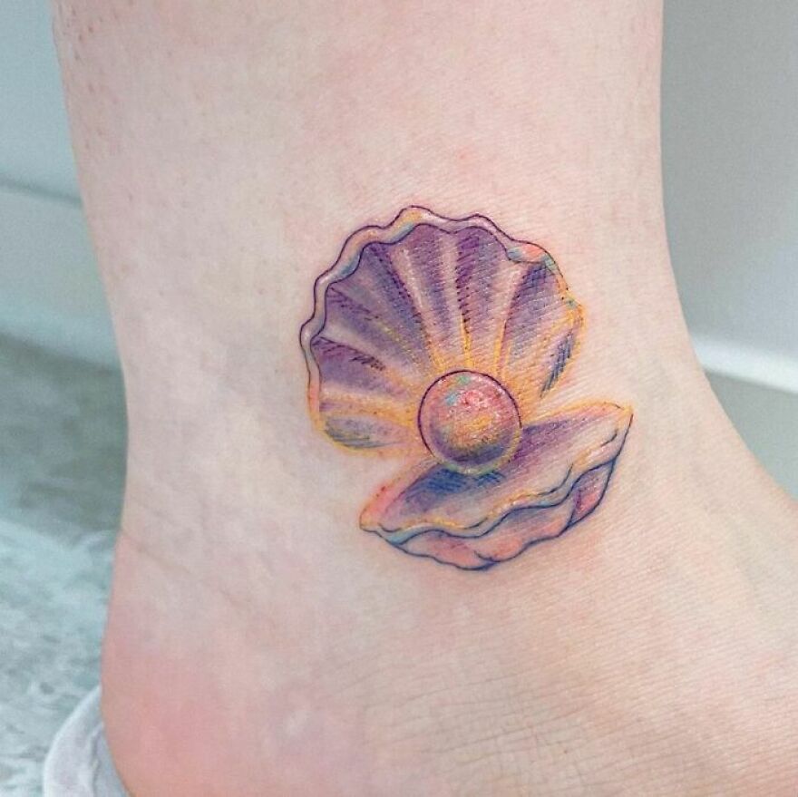colorful pearl in a shell tattoo on the leg