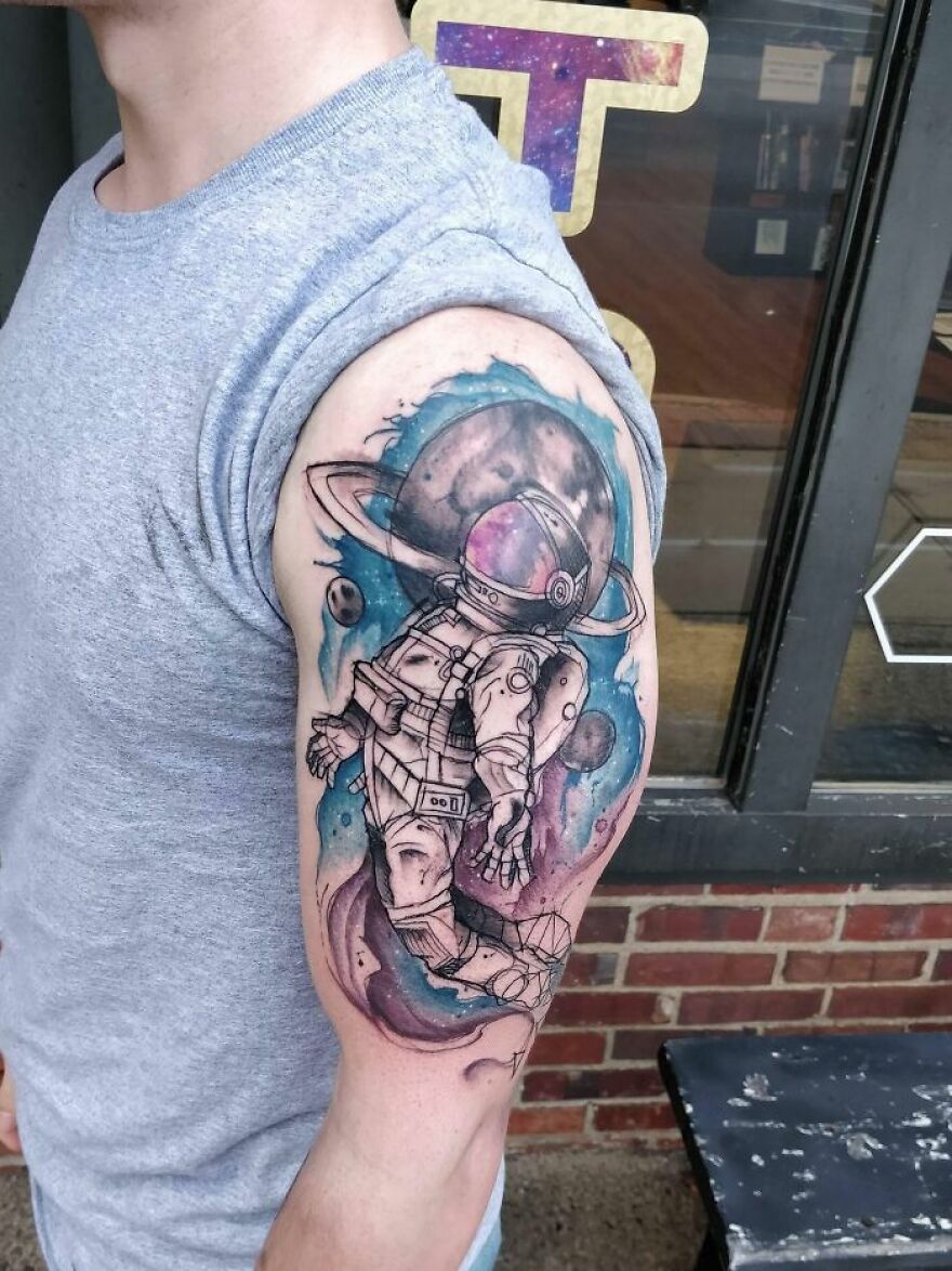 colorful astronaut tattoo on the arm