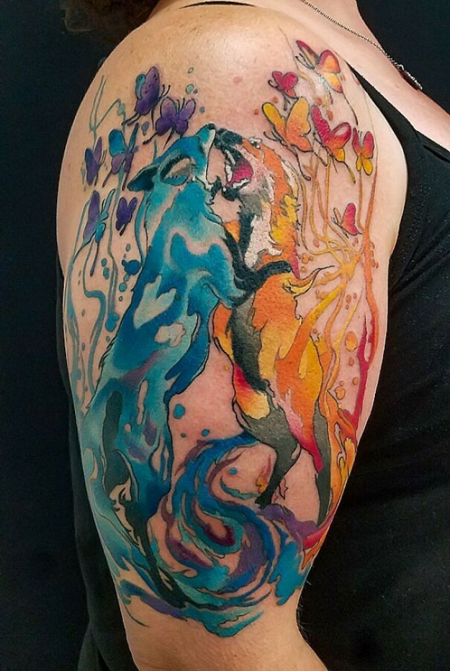 blue and red foxes tattoo on the arm