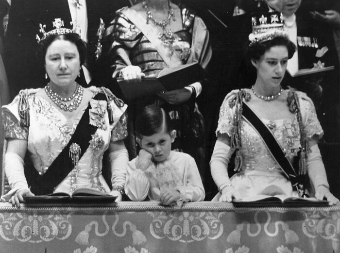 La reina Isabel; la reina madre, la princesa Margarita y un aburrido príncipe Carlos viendo la ceremonia de coronación de la reina Isabel II. Abadía de Westminster, 1953