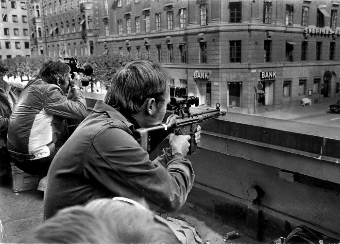 Press Photographers And Police Snipers Lie Side By Side On A Roof Opposite The Kreditbanken Bank On Norrmalmstorg Square In Stockholm. A Misfired Robbery Turned Into A Six-Day Standoff That Gave Birth To The Phrase "Stockholm Syndrome", Stockholm, Sweden 1973 