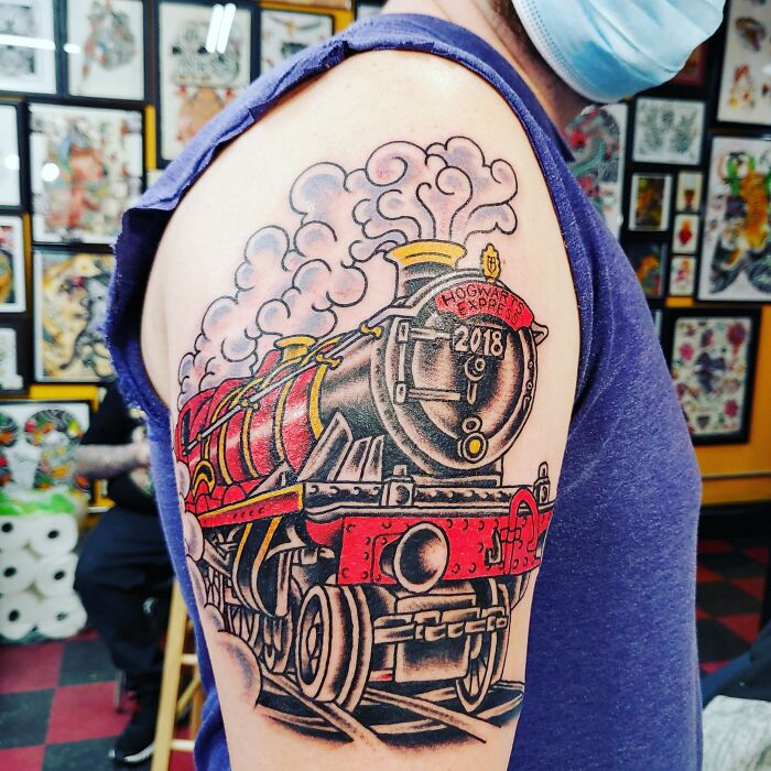 Tattoo of Hogwarts Express on an arm, with vibrant colors and detailed design, perfect for Harry Potter fans.