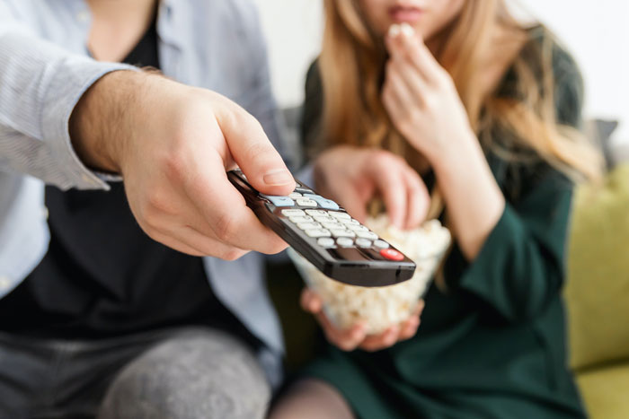 People holding tv remote
