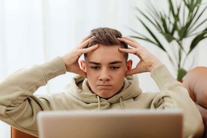 Boy holding hands on the head watching and thinking