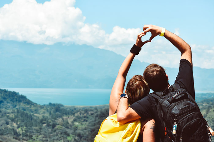 Couple travel and making heart symbol