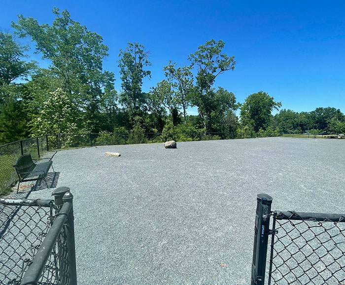 Nuestro encantador parque para perros de la Asociación de Propietarios. Sin sombra, sin césped, solo grava y rocas