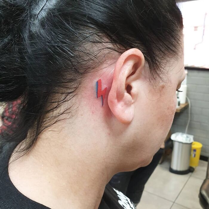 Colorful lightning bolt ear tattoo design.