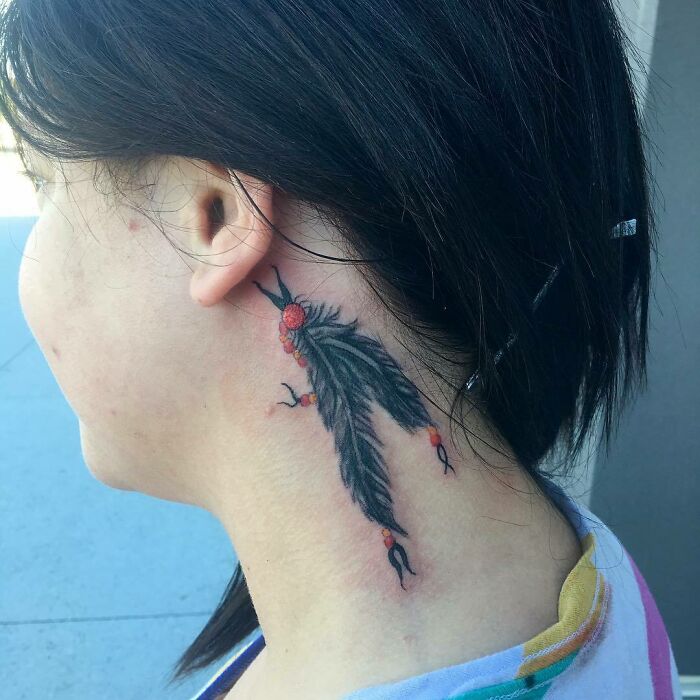 ear tattoo of two feathers