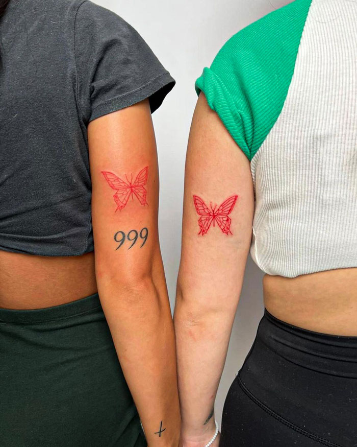 Red ink matching butterfly arm tattoos