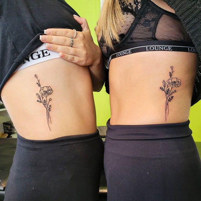 Matching flower bouquet tattoos on the ribs