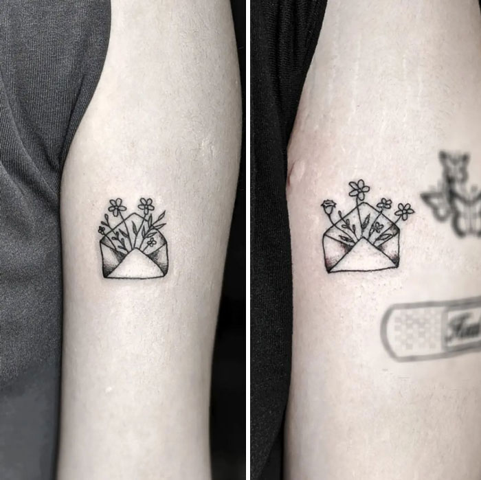 Matching friend tattoos of an envelope with flowers, symbolizing friendship.