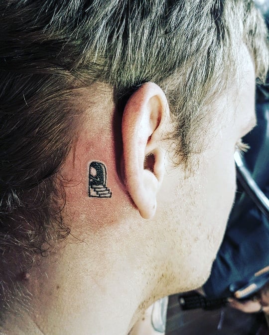 Ear tattoo with staircase and arch design behind the ear.