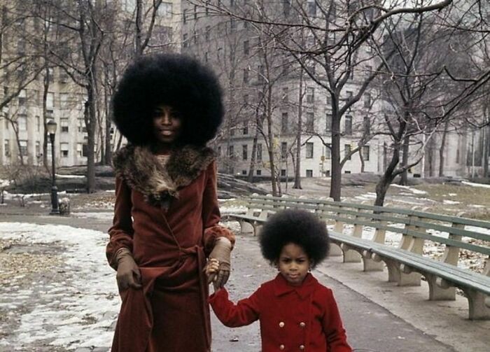 Mom and a daughter with afro hairstyle in a park 