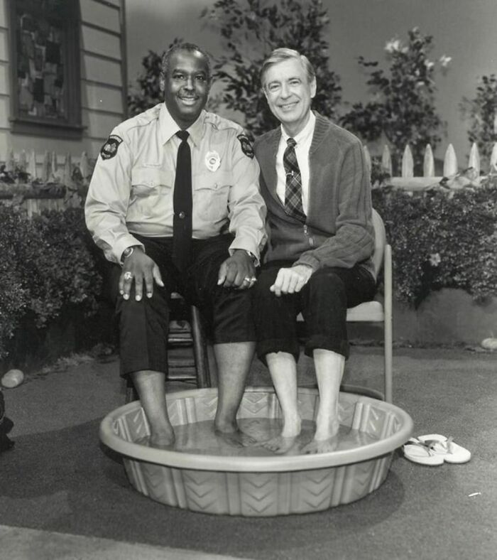 Cop and a man sitting on chair with their feet in a mini pool 