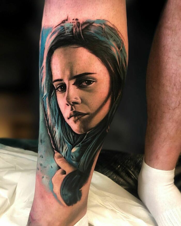 Tattoo of a woman's face with blue hair on a calf, inspired by the Wizarding World.