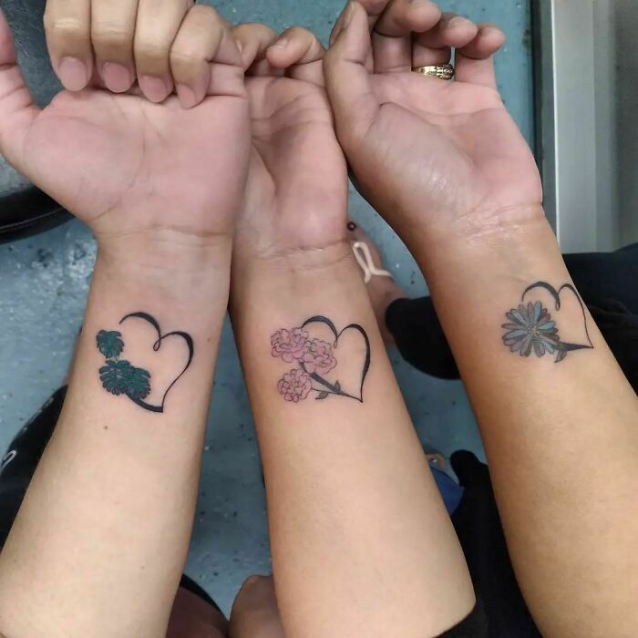 Three matching floral heart tattoos