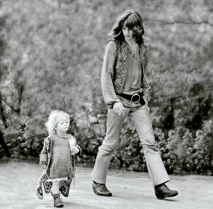 Hippie looking man walking with his daughter on the street 
