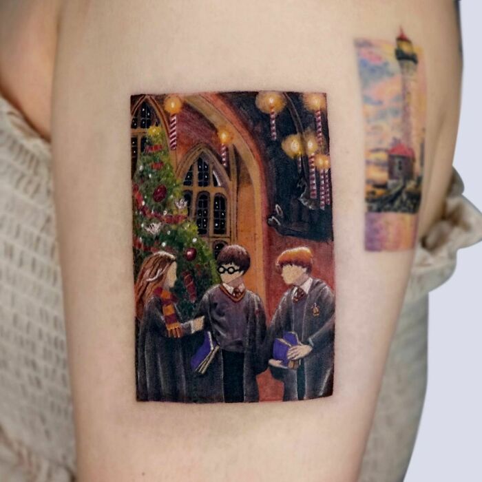 Harry Potter tattoo featuring characters in a festive Hogwarts scene with Christmas decorations.
