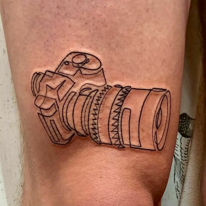 Single line camera elbow tattoo