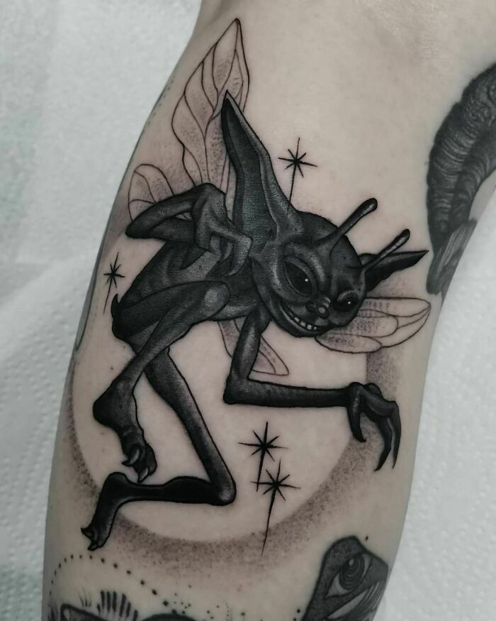 Creepy black and grey Harry Potter tattoo of a mischievous creature with wings on forearm.
