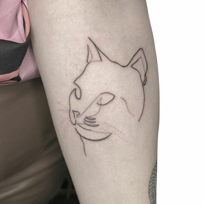 Single line cat face arm tattoo