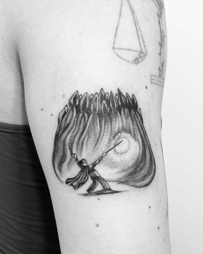 Arm tattoo featuring a wizard casting a spell, inspired by the Wizarding World.